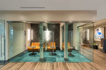 a room with glass walls and furniture and a blue rug